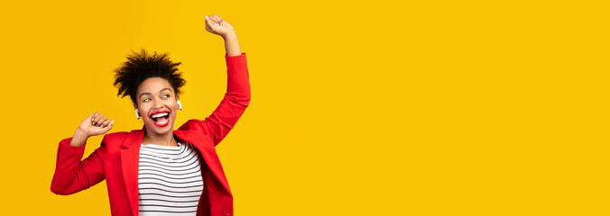 Smiling black girl listening to music and dancing at studio