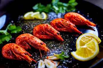prawns fried with spices with sauce and lemon slices