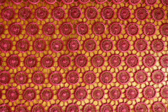 Red crochet lacy fabric on wood from above