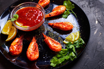 prawns fried with spices with sauce and lemon slices
