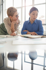 Two modern businesswomen working on project, copy space