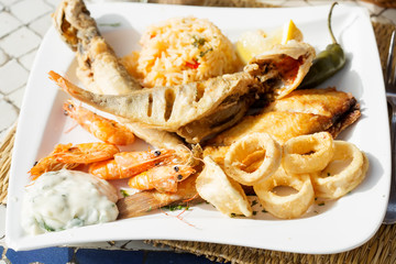 Seafood plate. Fish, calamari, shrimps, green pepper with rice and vegetables 