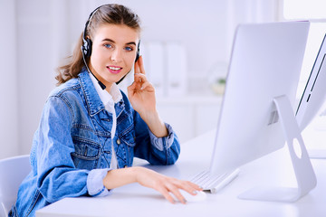 Smiling female customer service operator working on computer in office