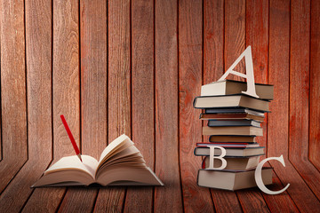 Paper Cut Letters on Pile of Books on Wooden Background and Open Book with Pencil. Writing Novel Concept. Study and Learn Design.