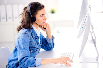 Young call center female agent browsing the internet on her computer