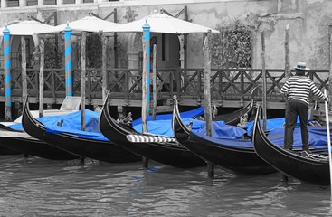Fototapeta na wymiar Black and white and blue shot of gondola boats on the Grand Canal in Venice, Italy