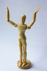 Wooden figure,isolated on white. Mannequin spreads his hands over his head on white background