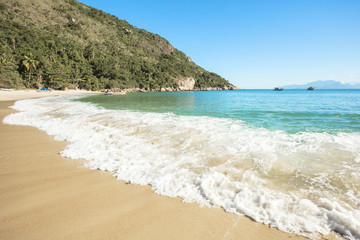 Obraz premium Vacation on the Meros(praia dos Meros) beach with clean sand, turquoise ocean water and blue sky with clouds on a sunny day. Panoramic view of the beach in Ilha Grande, south of Rio de Janeiro, Brazil