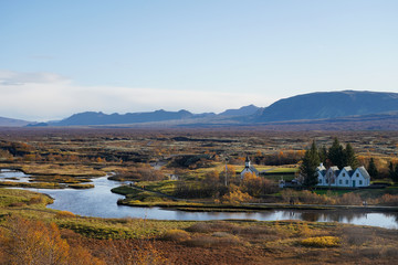 small village and old church with stream and mountain background near Thingvellir national park, Iceland