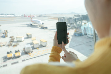 Woman hand hold smartphone at airport