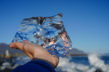 tourist hand holding crystal ice at diamond beach Iceland 