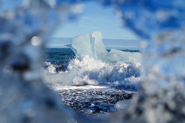image of ice frame focus on big ice piece crash by wave of ocean at Diamond beach Iceland