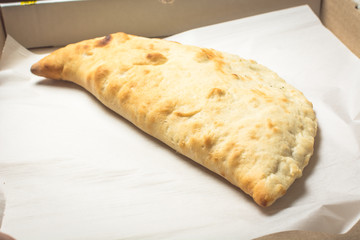 Baked meat pie in an open box.