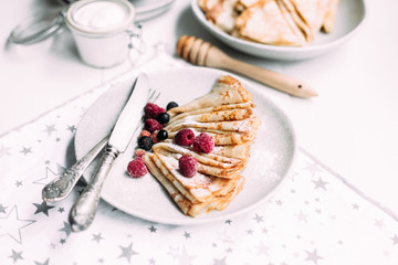 Pancakes with wild berries in a plate.Maslenitsa