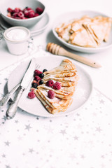 Pancakes with wild berries in a plate.Maslenitsa