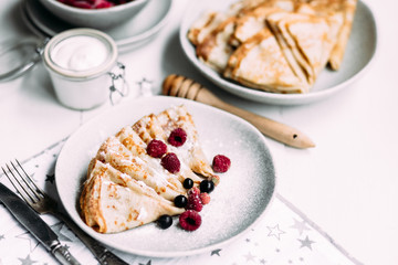 Pancakes with wild berries in a plate.Maslenitsa