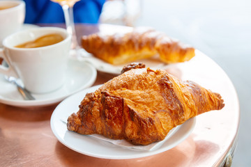 Breakfast with coffee and croissants on table