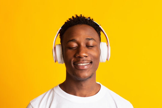 Portrait of Calm african american guy smiling and listening to music