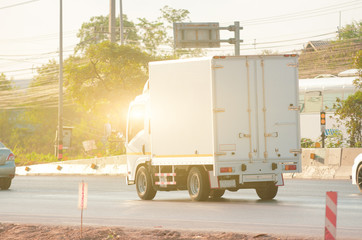 Small white truck for logistics running on the road.