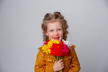 Naklejka premium portrait of a smiling child a blonde girl with a bouquet of flowers isolated on a white background