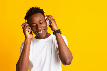 Smiling african man listening to music in headphones