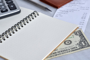 Close-up view, Blank notebook for daily expenses with dollar cash, bill, wallet, pencil and calculator is elements.