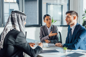 multicultural business partners talking on meeting with translator in office