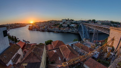Panorama old city Porto at river Duoro,with Port transporting boats at sunset timelapse, Oporto,...