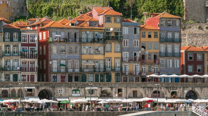 traditional quaint houses in the old, vintage and touristic ribeira district of Porto at sunny day timelapse, Portugal