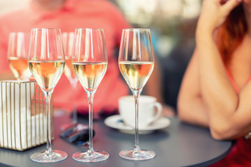Close-up detail table with many filled glasses of white champagne prosecco at party celebration...
