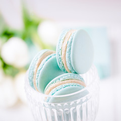 Mint or tiffany color macaron or macaroon dessert with vanilla cream in glass. Copy space