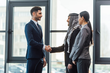 professional multicultural business partners shaking hands on meeting with translator in office