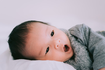 Smiling baby boy lying on a white bed, Family morning at home,Children hygiene.