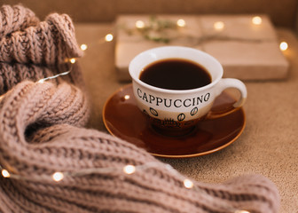A cup of coffee and a book on a plaid. Sweet home. Good morning. Reading and home relaxation concept. Top view, flatlay