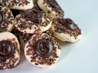 Chocolate thumbprint cookies covered in sprinkles piled up on a white table, delicious sweet treat!