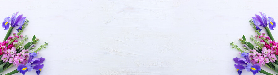 spring bouquet of pink and purple flowers over white vintage wooden background. top view, flat lay