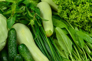 Fresh green vegetables and herbs as a background.