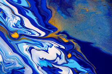 Fluid art texture. Background with abstract mixing paint effect. Liquid acrylic artwork that flows and splashes. Mixed paints for website background. Blue, golden and white overflowing colors.
