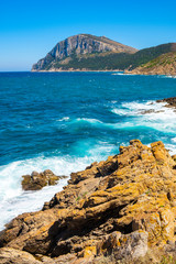 Panoramic view of Capo Figari cape cliffs and rocks with Monte Ruju mount at the Tyrrhenian Sea coast in Golfo Aranci, Sardinia, Italy