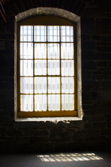 Fototapeta na wymiar old window in stone building in sunlight