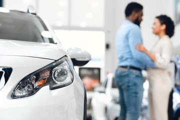 Fototapeta premium Unrecognizable Couple Hugging Standing Near Auto In Dealership Center