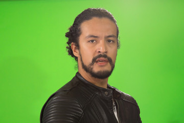 Obraz premium portrait of attractive Latin young in rocker jacket, on green background, with acoustic guitar
