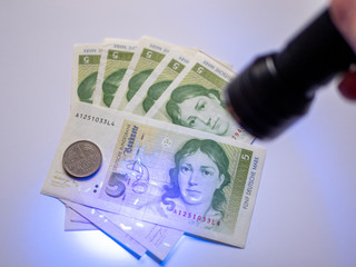 Bunch of old Deutsche Mark under UV Light Lamp