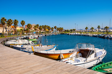 Fototapeta na wymiar Golfo Aranci, Sardinia, Italy - Panoramic view of Golfo Aranci yacht port - Marina di Golfo Aranci - with seashore park boulevard at the Tyrrhenian Sea coast