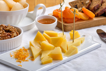 Set of various appetizers for wine - cheese, walnuts, dried apricots, honey and canned pear