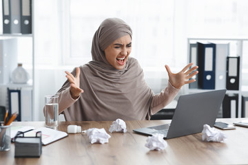 Furious Arabic Businesswoman Looking At Laptop Screen And Raising Hands