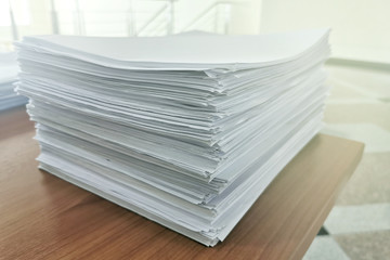 Pile of document on the table;unfinished work or workload concept