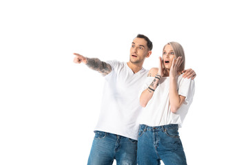 shocked young tattooed couple pointing with finger away isolated on white