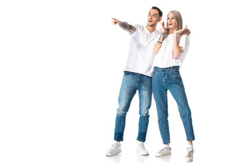 Fototapeta premium shocked young tattooed couple pointing with finger away isolated on white