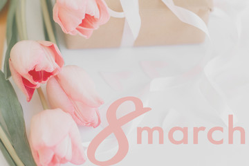 8 march. Happy womens day greeting card. 8 march text on pink tulips and gift box with ribbon on...